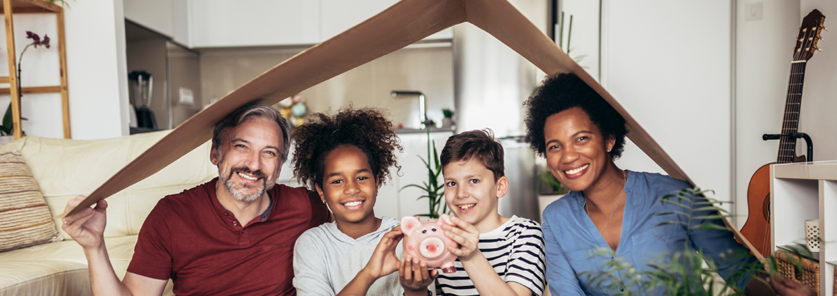 family-footer-short family sitting in their house holding a cardboard roof showing safety and security